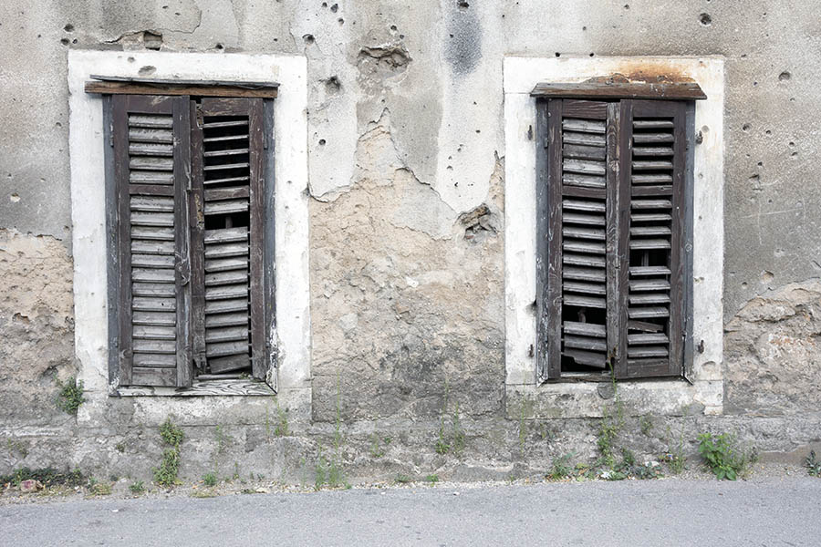 Photo 26174: Facade with two decayed, brown shutters in a decayed, grey, plastered wall