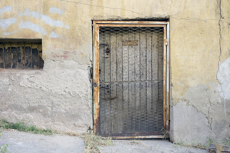 Photo 26332: Facade with worn, grey door with lattice in front