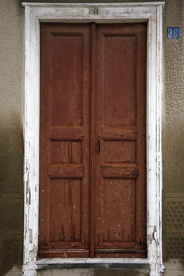 Photo 26833: Worn, brown, panelled double door in a white frame
