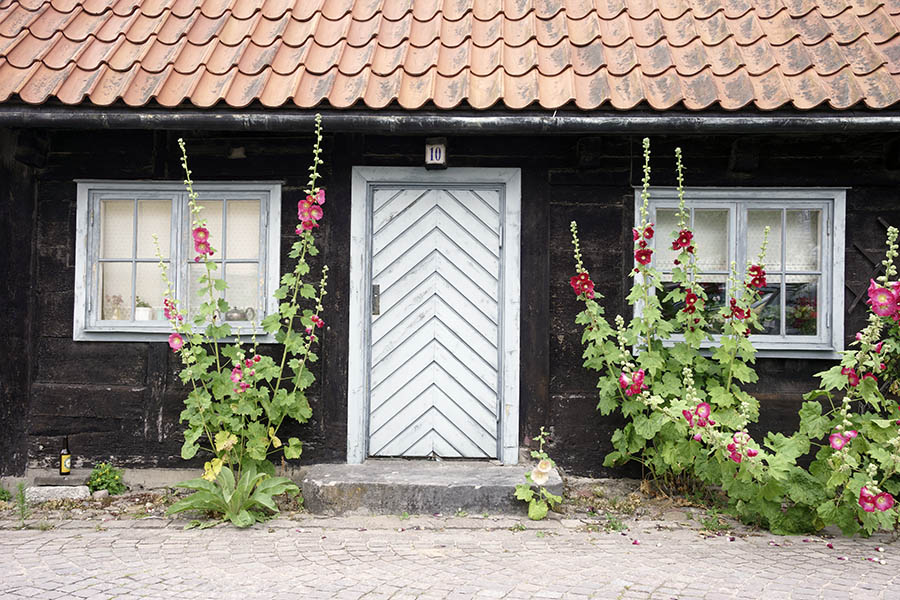 Photo 27085: Facade with grey and teal door of diagonal boards and two windows with two frames and eight panes each