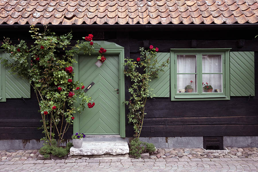 Photo 27088: Facade with green door of diagonal boards and two windows with two frames and four panes each.