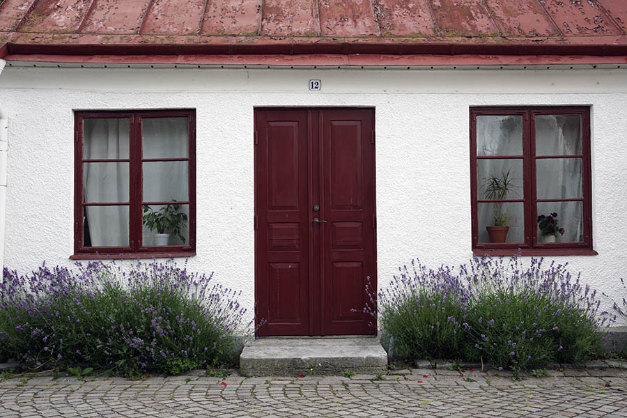 Photo 27092: Facade with panelled, red double door and two windows with two frames and six panes each.