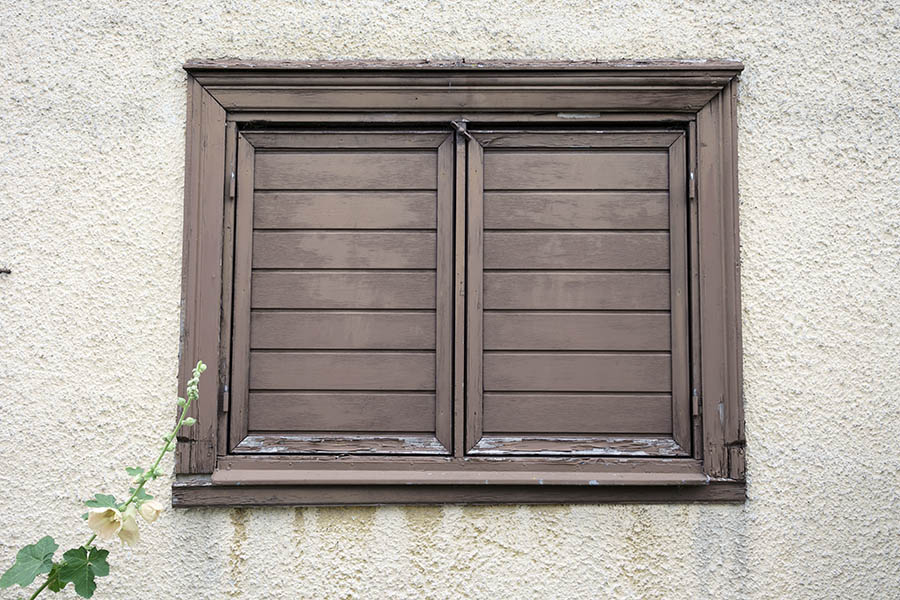 Photo 27103: Worn, brown window with double shutters