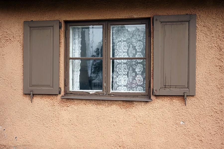 Photo 27117: Worn, brown window with two panes and four frames. Shutters.
