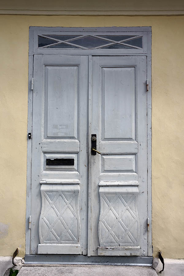 Photo 27294: Worn, light grey, panelled, carved double door with top window