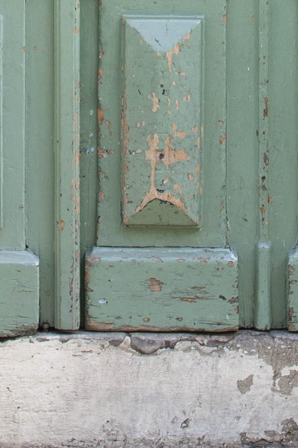 Photo 02168: Worn, panelled, light green door with grated top window