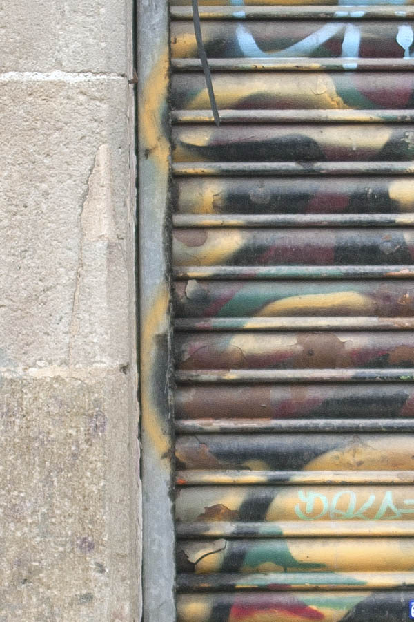 Photo 02353: Worn, brown grafittied metal security shutter and formed top window