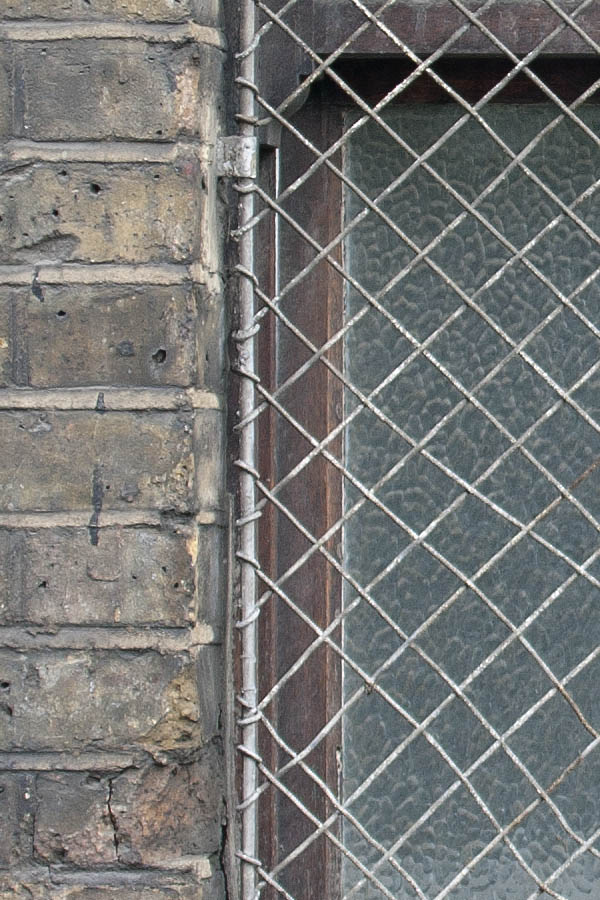 Photo 05257: Grated, oiled sash window with two panes