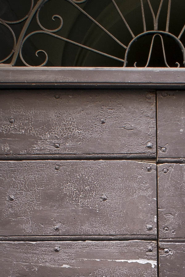 Photo 07946: Worn, brown double door made of planks with latticed fan light and pilaster