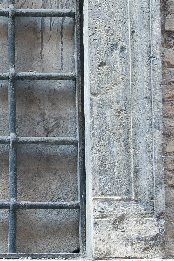 Photo 08121: No window. A grey, barred embrasure in a sandstone pilaster.