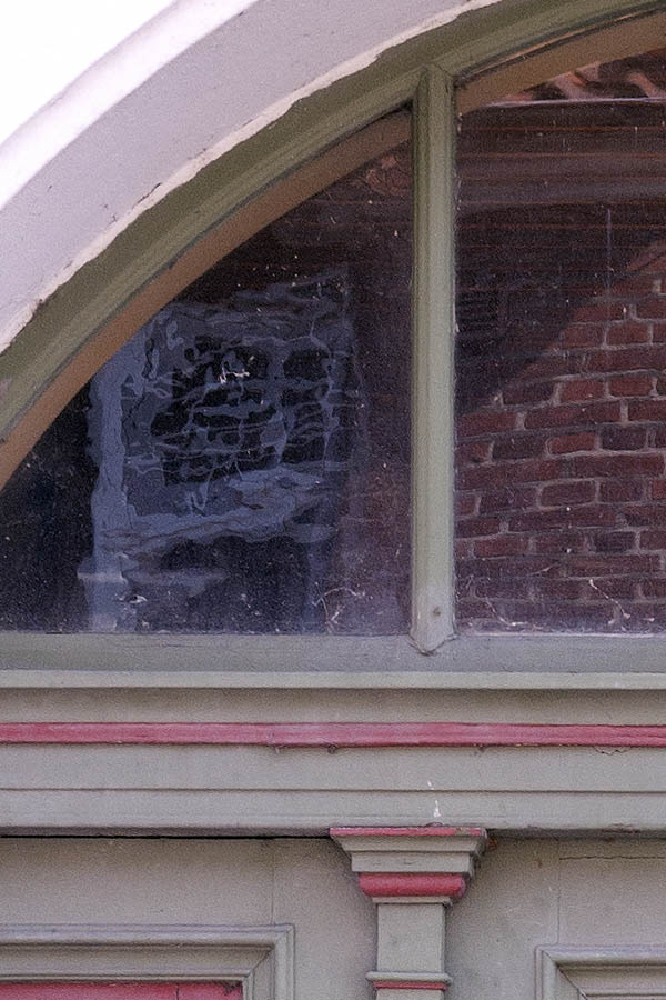 Photo 08764: Worn, panelled, green and red door with sidepieces and large fan light.
