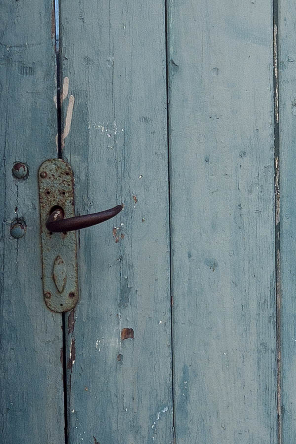 Photo 09446: Formed, teal door made of planks leading to a garden