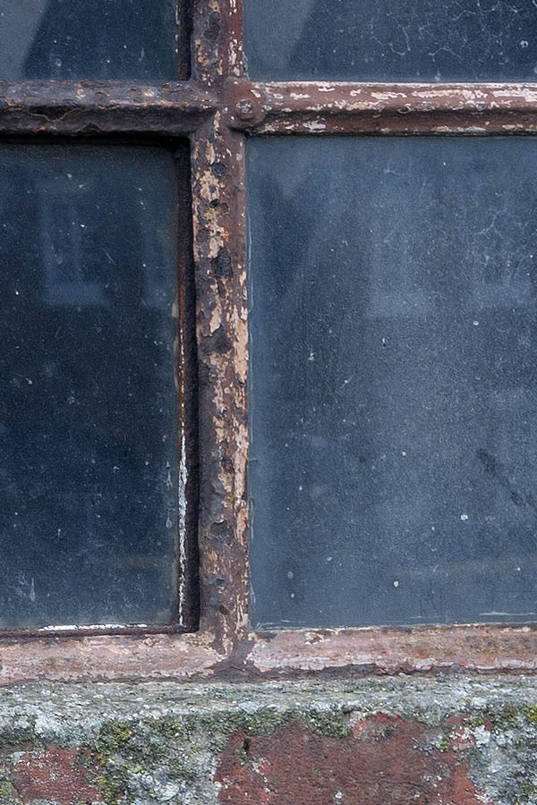 Photo 09714: Formed, rusty, brown metal stable window
