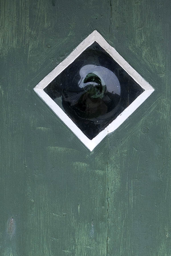 Photo 09784: Worn, green, black and white half-door made of planks with a diamond-shaped door light