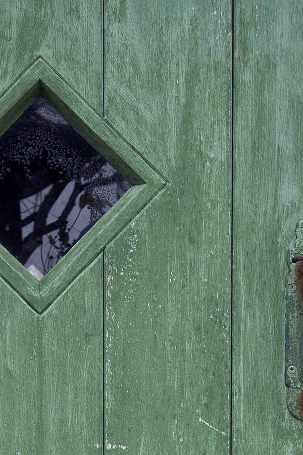 Photo 09807: Worn, green half-door made of planks with a diamond-shaped door light