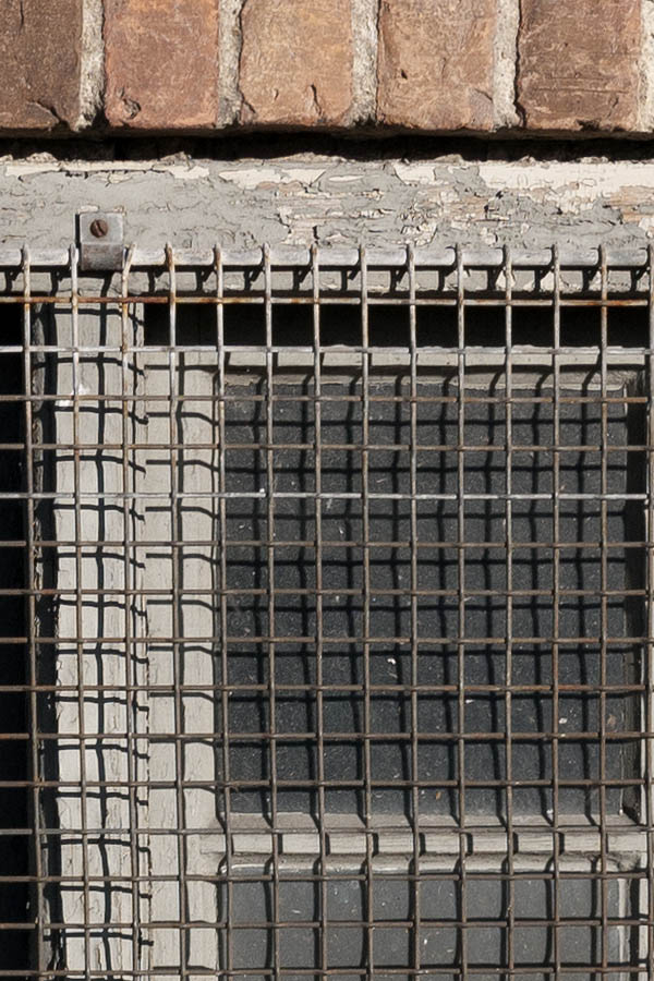 Photo 10483: Grated, grey cellar window with two frames and eight panes