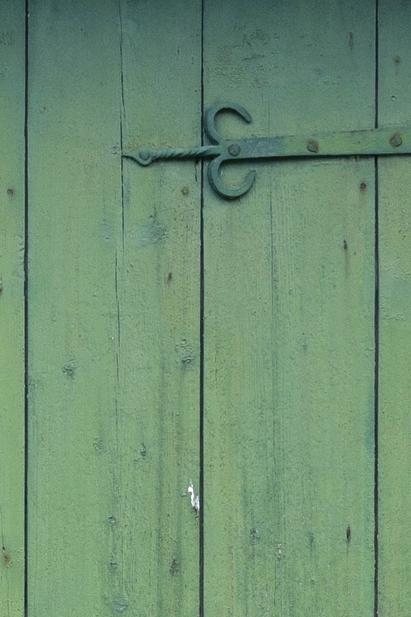 Photo 11112: Worn, lopsided, green and red gate made of planks