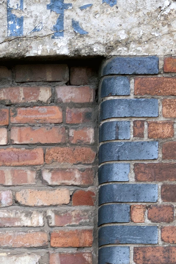 Photo 11610: No window. Embrasure in a worn wall. Blue and red brickwork..