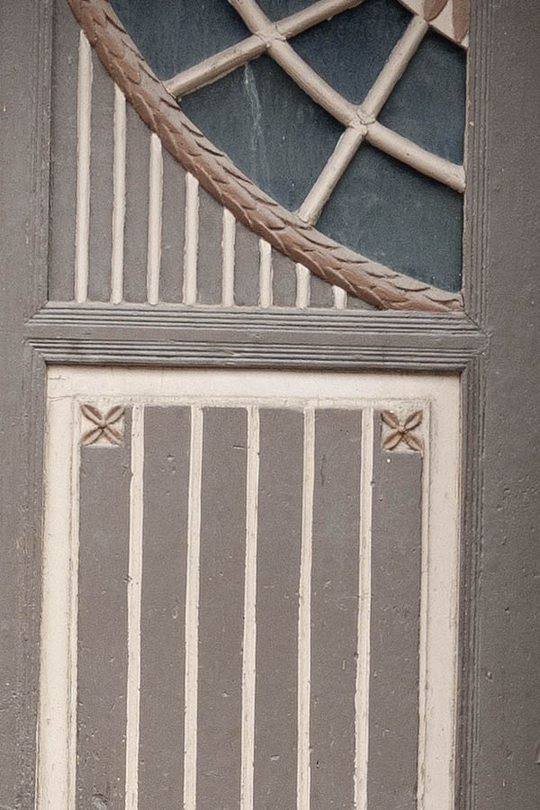 Photo 12378: Worn, carved, panelled, brown and light yellow double door with a lopsided pilaster and formed door 