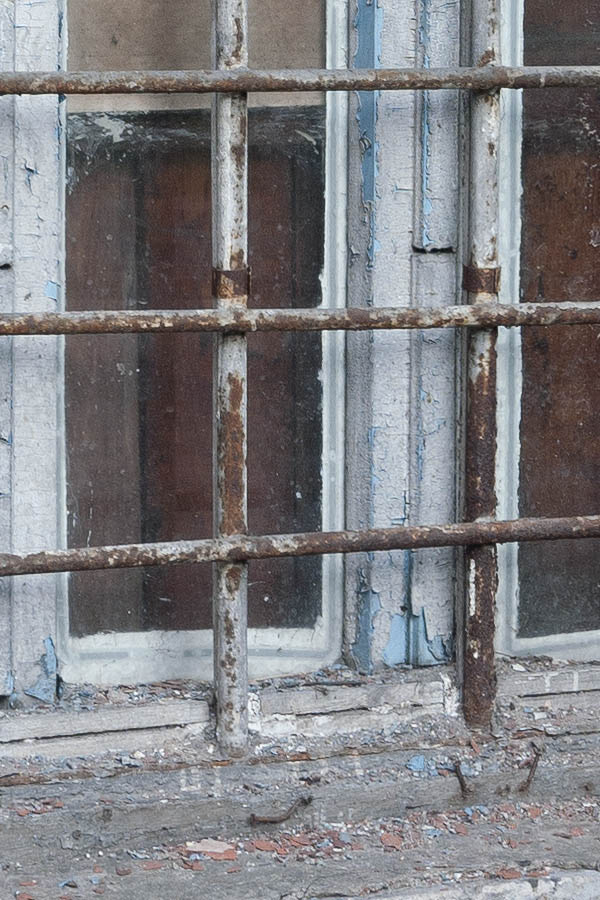 Photo 12943: Worn, unpainted, barred window with three frames and six panes