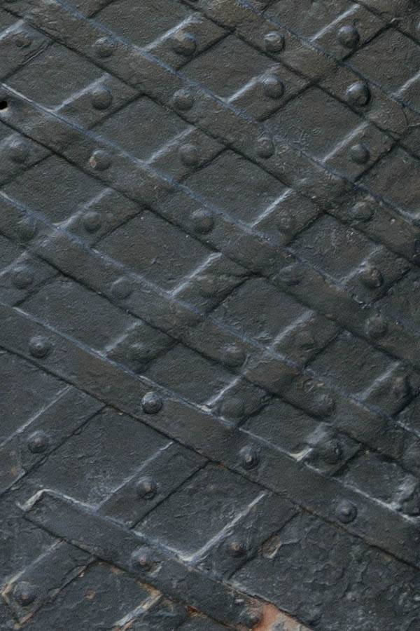 Photo 13764: Worn, black metal door with metal decoration