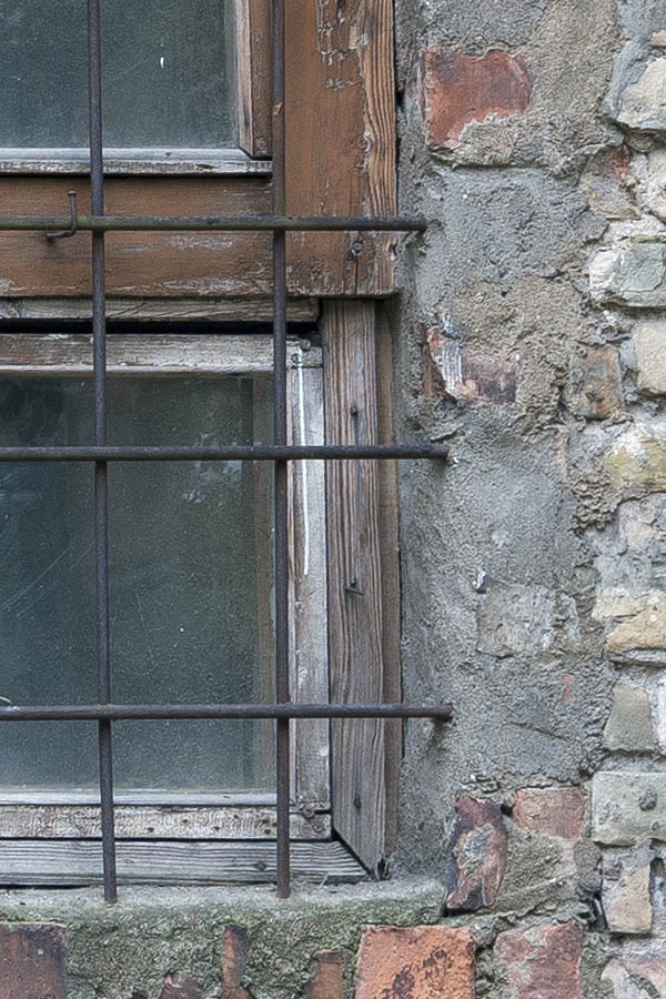 Photo 19150: Worn, barred, orange and brown window with three frames and 12 panes