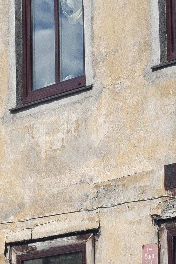 Photo 19771: Facade of yellow, plastered house with 13 T-post windows and a brown door
