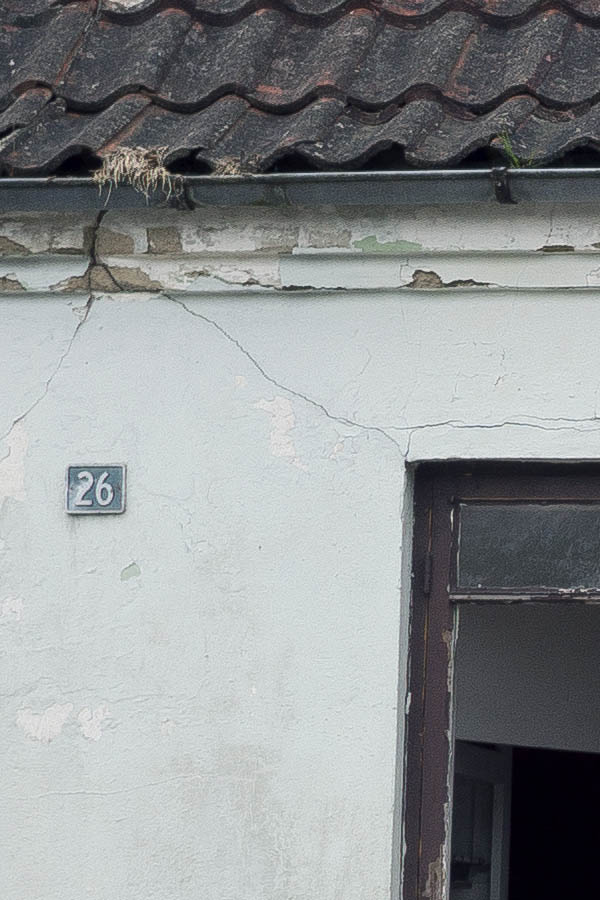 Photo 25146: Facade of white house with three brown windows with broken glass