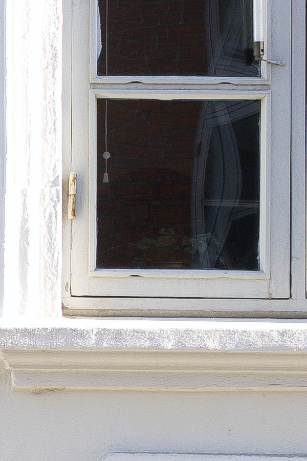 Photo 25298: Facade with panelled, grey door and three grey windows in a plastered, white wall