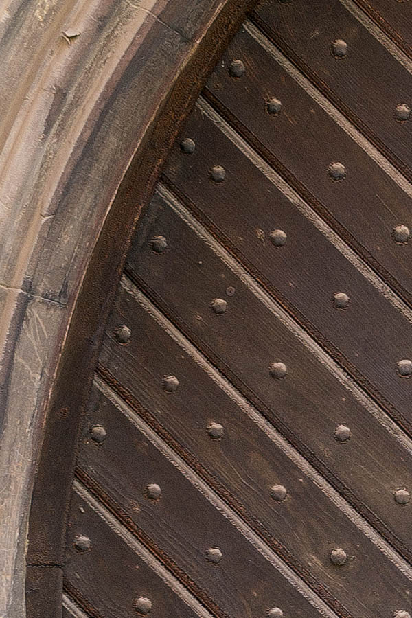 Photo 25353: Formed, brown church gate  with diagonal boards, many nails, and a barred door light
