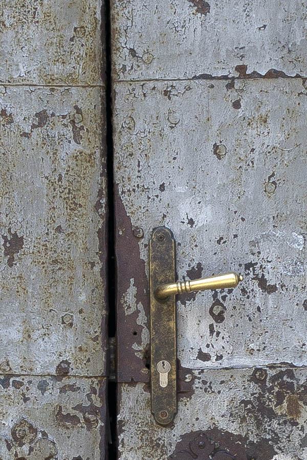 Photo 25506: Worn, grey and brown double door covered with metal plates