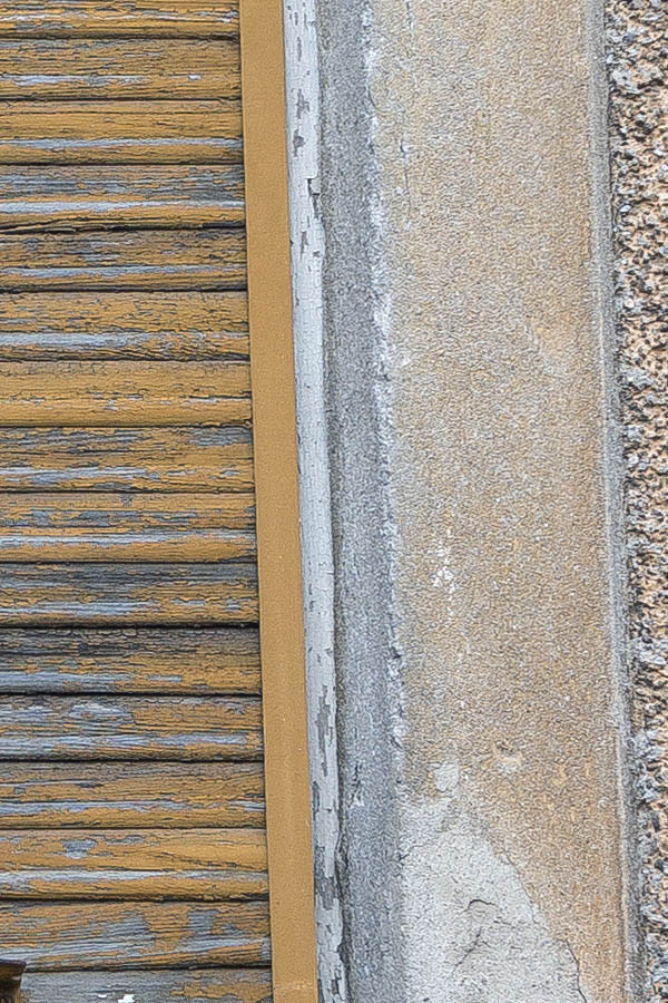 Photo 25582: Facade with three worn, yellow, wooden security shutters