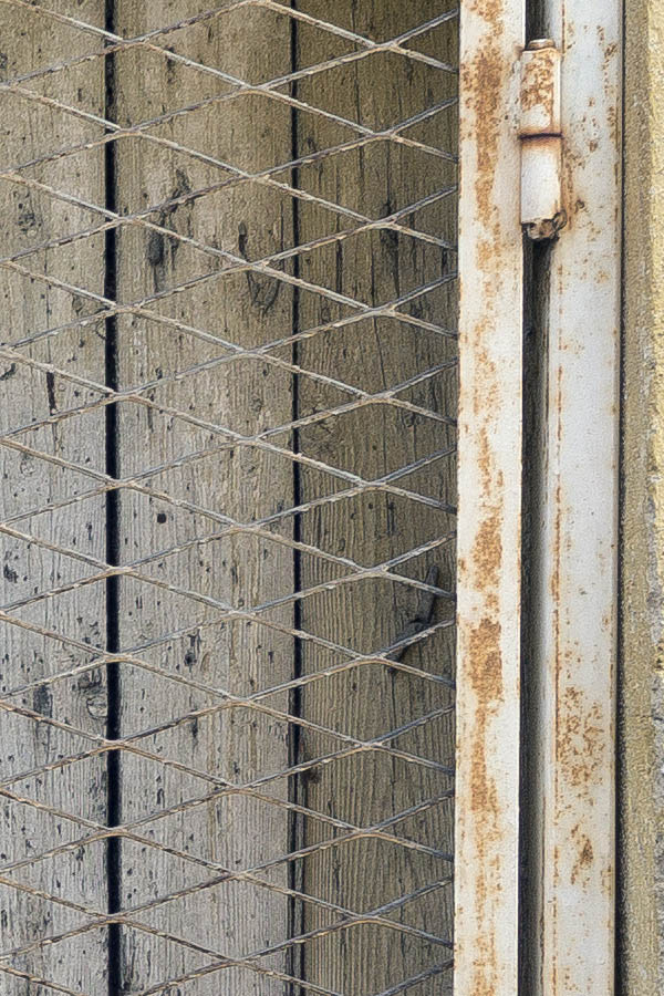 Photo 26332: Facade with worn, grey door with lattice in front