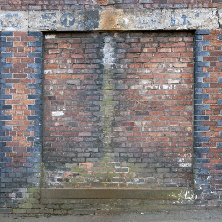 Photo 11610: Worn, red and black brick wall with indentation