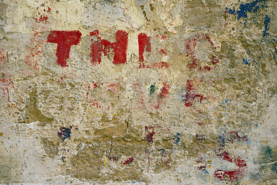 Photo 24195: Worn, yellow, plastered wall with grafitti