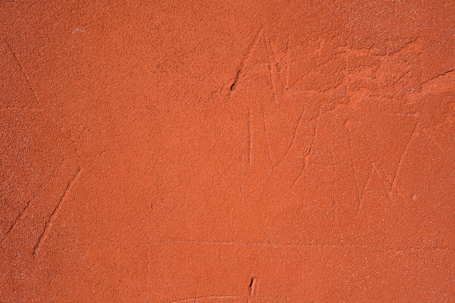 Photo 24442: Worn, red, plastered wall with traces of grafitti