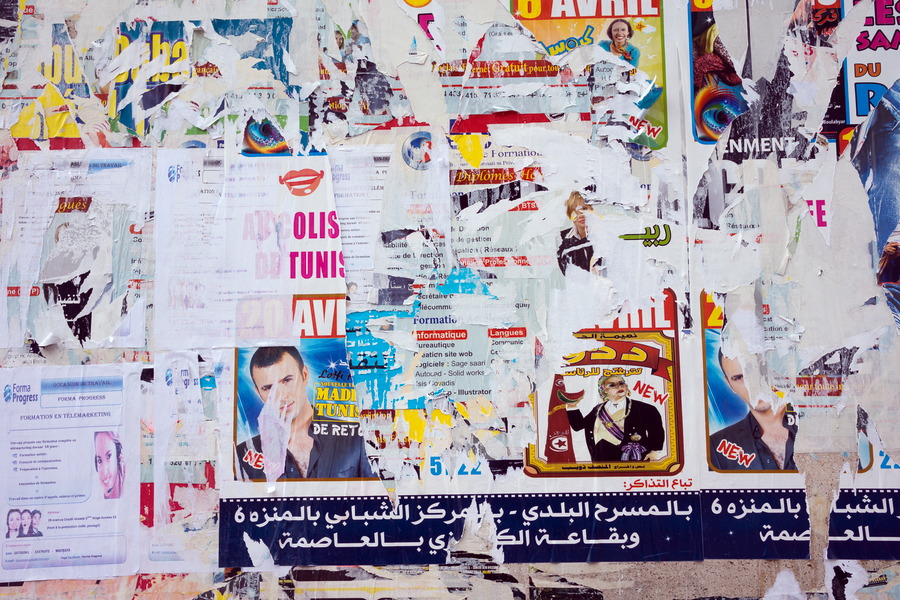 Photo 24542: Wall with worn posters in white, blue, red and yellow