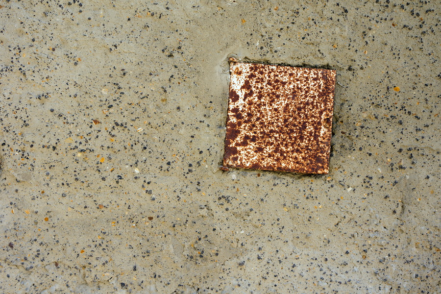 Photo 24684: Wall with grey and black plaster and a rusty hatch