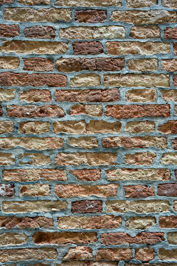 Photo 24852: Worn brick wall in yellow and red with grey or blue mortar