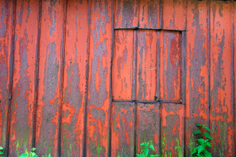 Photo 25448: Red and rusty wall of corrugated iron with a hatch