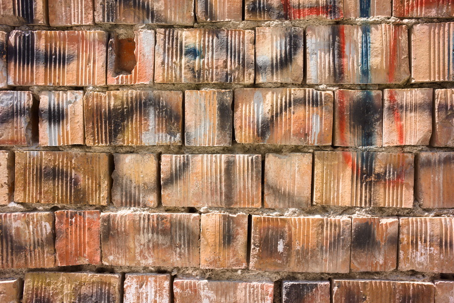 Photo 27405: Rough, orange wall of bricks with grafitti