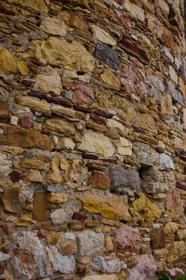 Photo 27439: Worn stone wall with red, yellow and brown stones