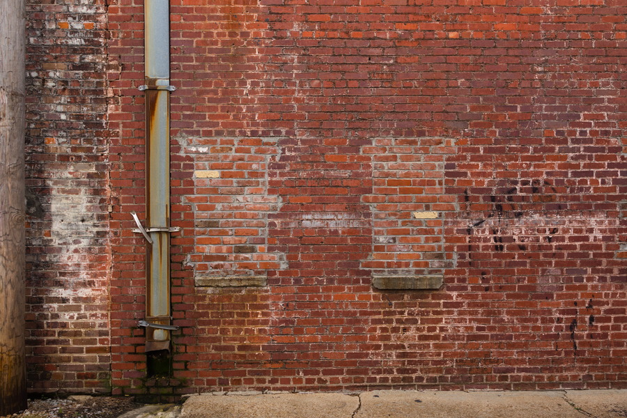 Photo 27517: Worn, red brick wall with drainpipe