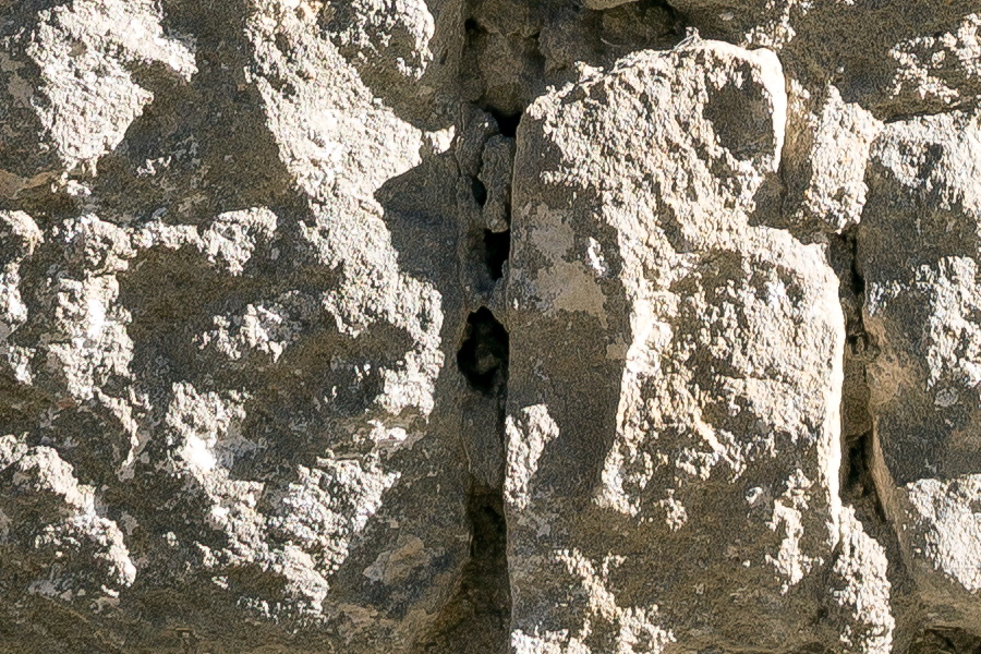Photo 24691: Worn, light yellow sandstone wall
