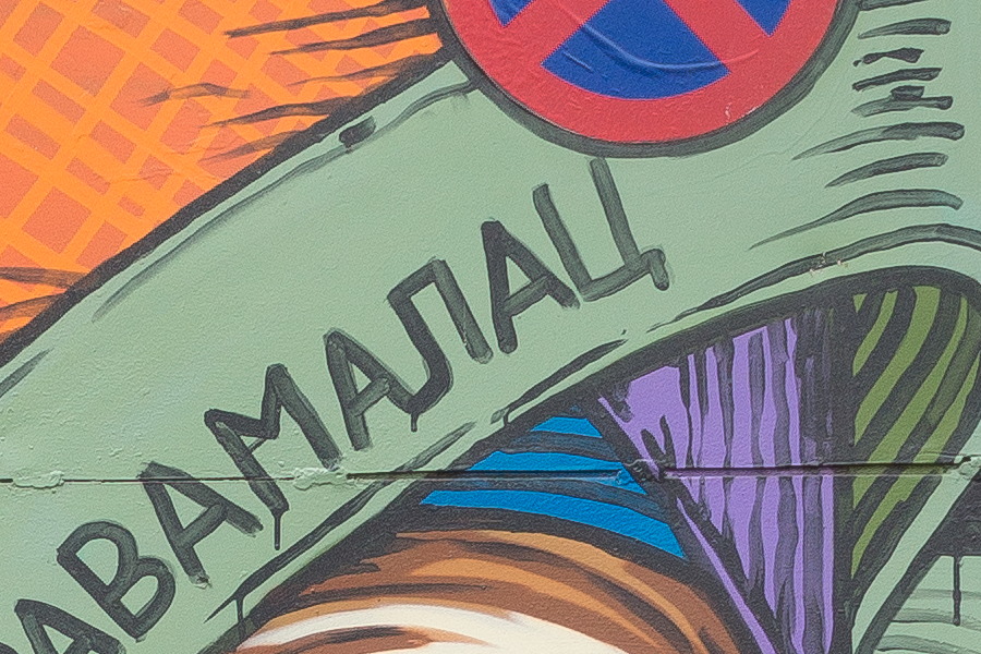 Photo 26160: Metal double door covered with grafitti: A face wrapped in orange, green, blue and yellow strips