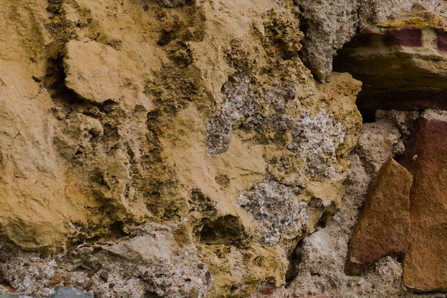 Photo 27439: Worn stone wall with red, yellow and brown stones